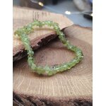 Bracelet péridot baroque présenté dans la main en gros plan, chips vert olive translucides pour énergie de renouveau et sensation de légèreté