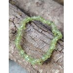 Bracelet péridot baroque sur tronc de bois veinuré en lumière naturelle, chips verts translucides pour renouveau, vitalité douce et clarté du cœur