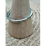Bague réglable en cuivre blanc, vue de dos sur support en bois, posée sur rondin ; apporte apaisement, clarté et confiance.