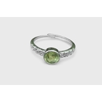 Bague péridot facetté, monture réglable cuivre blanc, sur fond blanc ; aide à se recentrer, à calmer les tensions et à garder le moral.