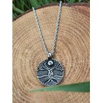 Collier Yggdrasil argenté sur rondin de bois en décor forestier, énergie de renouveau et cheminement intérieur