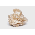 Rose des sables beige (gypse) sur fond blanc, formation cristalline en pétales, ombre douce; symbolique : ancrage, stabilité, clarté.