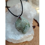 Pendentif en garniérite vert d’eau sur cordon noir, pierre polie posée sur géode blanche en décor minéral, pierre naturelle liée au réconfort émotionnel, au recentrage et à la tranquillité intérieure.