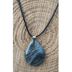 Pendentif goutte en pierre de lune noire polie sur cordon noir, posé sur une tranche de bois, pierre naturelle associée au recentrage, à la clarté émotionnelle et à la tranquillité intérieure.