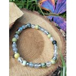Bracelet vampire énergétique sur rondin de bois avec carte et feuillage, pierres naturelles pour se préserver des ambiances lourdes et retrouver un axe stable