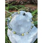Bracelet vampire énergétique posé sur amas de quartz avec herbes en arrière-plan, trio labradorite, serpentine et cristal de roche pour nettoyage subtil et respiration mentale