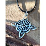 Gros plan sur pendentif nœud de sorcière argenté avec cordon noir, décor pierre claire et bois sombre, contraste minéral et protection symbolique