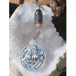 Bijou de sac Odin Sleipnir avec pierre de soleil   grenat, photo sur géode de quartz blanche. Création Magic Gaïa : énergie, confiance, stabilité.