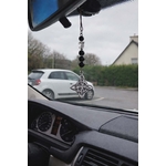 Bijou de rétroviseur « nœud de sorcière » : perles de tourmaline noire sur cordon, pendentif nœud celtique argenté au miroir. Photo dans la voiture, route en arrière-plan. Création Magic Gaïa, pour protection et ancrage.