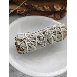 Bâton de sauge blanche à brûler (smudge) ficelé, posé sur bol en céramique blanc, fond sombre et bois. Accessoire pour fumigation, rituel, méditation, yoga, purification énergétique, nettoyage des lieux, protection, clarté et apaisement.