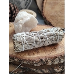 Bâton de sauge blanche à brûler (fumigation/smudge), fagot ficelé, posé sur rondin de bois avec amas de quartz et tranches de bois. Idéal pour rituel, méditation, purification énergétique, nettoyage des lieux, protection et apaisement