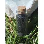 Sel noir ritualisé fait maison Magic Gaïa en flacon verre avec bouchon liège, photo sur herbes et fond clair; usage rituel protection, purification, ancrage, nettoyage énergétique.