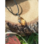 Pendentif citrine sur cordon noir, posé sur champignon et mousse avec carte rouge en bas, pierre naturelle liée à la lucidité, à l’énergie chaleureuse et à l’élan personnel.