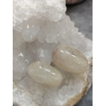 Deux pierres roulées citrine posées sur support naturel avec amas de quartz en arrière-plan, ambiance minérale, lumière douce, énergie solaire, joie, confiance, concentration, motivation, abondance, photo produit Magic Gaïa.