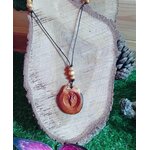 Pendentif en bois Gaïa rond gravé sur cordon noir avec perles bois, posé sur tranche de bois et mousse, symbole Terre-Mère au style nature