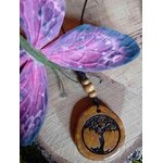 Gros plan sur pendentif Arbre de Vie en bois gravé, cordon noir avec perles bois, décor fleur violette et tranche de bois, esprit terre et croissance