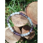Bracelet clairvoyance en pierres naturelles posé sur champignons et herbe, création Magic Gaïa en Quartz Seven et Péristérite, écoute intérieur