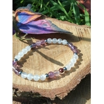 Bracelet lithothérapie clairvoyance sur tranche de bois avec papillon violet et herbe, perles blanches et violettes, apaisement et perception subtile