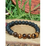 alt=Bracelet œil de tigre et pierre de lave 8 mm sur élastique, décor bois et herbes, protection, ancrage, assurance