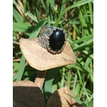 Bague onyx noir argent 925 anneau filigrané photo nature sur feuille beige fond herbes vertes intentions associées calme maîtrise de soi discernement