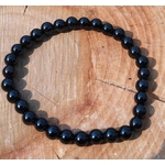 Bracelet Onyx noir en perles lisses rondes, vue du dessus en décor naturel, recentrage, lucidité et maîtrise émotionnelle.