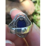 Vue arrière d’une bague argent 925 filigranée avec lapis lazuli bleu, tenue entre les doigts, pour soutenir confiance, clarté et communication.