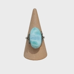 Bague réglable en argent avec larimar bleu ciel, présentée sur cône en bois sur fond clair, idéale pour apaiser, favoriser la communication et la sérénité