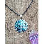 Pendentif arbre de vie en abalone et argent 925 sur cordon noir, posé sur rondin de bois avec papillon violet, bijou en pierre naturelle associé à la douceur, au recentrage et à l’harmonie intérieure.