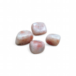 quatre-pierres-roulées-en-pierre-de-soleil-posées-sur-un fond blanc-r-teintes-creme-et-peche-pour-cultiver-joie-confiance-et-vitalité