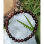 Bracelet œil de taureau 6 mm sur fond blanc, perles brun rouge et noir en cercle pour assurance calme et énergie protectrice