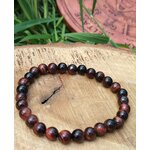 Bracelet œil de taureau 6 mm sur tranche de bois avec brins d’herbe, courage posé, enracinement solide et présence affirmée