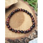Bracelet œil de taureau 6 mm sur tranche de bois clair avec feuillage, détermination stable et protection symbolique au quotidien