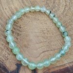 Bracelet préhnite 6 mm vert pâle translucide sur support en bois, ambiance naturelle pour recentrage, intuition calme et apaisement des pensées