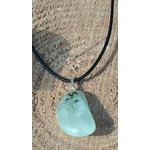 Pendentif en préhnite vert d’eau sur cordon noir, posé sur un amas de quartz blanc avec herbes en arrière-plan, pierre naturelle associée au recentrage, à la souplesse émotionnelle et à la sérénité.