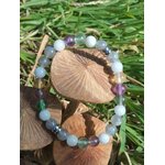 Bracelet Énergie lunaire sur herbe verte avec champignons bruns, nuances bleu-gris, vert et violet, équilibre émotionnel et intuition
