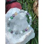 Bracelet pierres naturelles Énergie lunaire posé sur rondin de bois et feuillage vert, bijou ésotérique pour recentrage émotionnel
