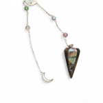 Pendule conique en labradorite, chaînette argentée ornée de perles multicolores et d’un croissant de lune, sur fond clair, pour guider l’intuition et la clarté.