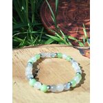 Bracelet endométriose sur rondin de bois avec herbes vertes en fond, jade vert, péristérite et labradorite pour soutien du féminin, sérénité et énergie plus douce