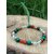 Bracelet prémenstruel 6 mm (malachite, cornaline, cristal de roche) posé sur pierre beige en extérieur, feuillage vert en arrière-plan, création Magic Gaïa; intention apaisement, équilibre émotionnel.