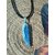 Pendentif cyanite bleue brute sur cordon noir, bélière argentée, posé sur bois et ailes de papillon; intention: clarté, sérénité.