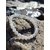Bracelet en perles rondes bleu ciel marbré et blanches posé sur une écorce, avec coquillages flous en arrière-plan, photo Bretagne, évoquant la douceur, l’expression apaisée et l’harmonie intérieure