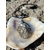 Pendentif pyrite naturelle sur coquillage blanc en extérieur en Bretagne, pierre ovale aux reflets métalliques avec cordon noir, symbole d’élan, de courage et de protection.