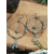 Créoles labradorite argentées posées sur tranche de bois, chaîne centrale et perles grises pour intuition et protection symbolique.