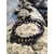 Bracelet Obsidienne Argentée 6 mm posé sur un rocher en bord de mer en Bretagne, perles sombres aux reflets métallisés pour protection profonde.