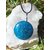 Pendentif apatite bleue ronde sur un amas de quartz  en extérieur, bijou en pierre naturelle associé à la communication, à l’assurance et à l’élan intérieur.