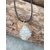 Pendentif cage spirale avec amas de quartz (cristal de roche), cordon noir, posé sur bois brut, pierre d’amplification et clarté.