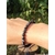 Bracelet Gabbro porté au poignet, perles bleu-noir en extérieur sur fond feuillage, bijou en pierre naturelle pour ancrage et stabilité