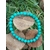 bracelet turquoise stabilisée en perles rondes posée sur champignons en bois  et herbes vertes talisman de protection en voyage et au quotidien