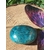 Galet d’apatite bleue polie ovale posé sur tranche de bois avec feuillage, pierre naturelle associée à la clarté d’esprit, à l’expression sincère et à l’élan intérieur.