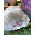 Boucles d’oreilles puces en rhodonite rose (perles rondes) sur tiges en acier inoxydable, posées au creux d’une géode de quartz avec feuillage en décor; ambiance douce, réconfortante, favorise l’apaisement émotionnel et la bienveillance.